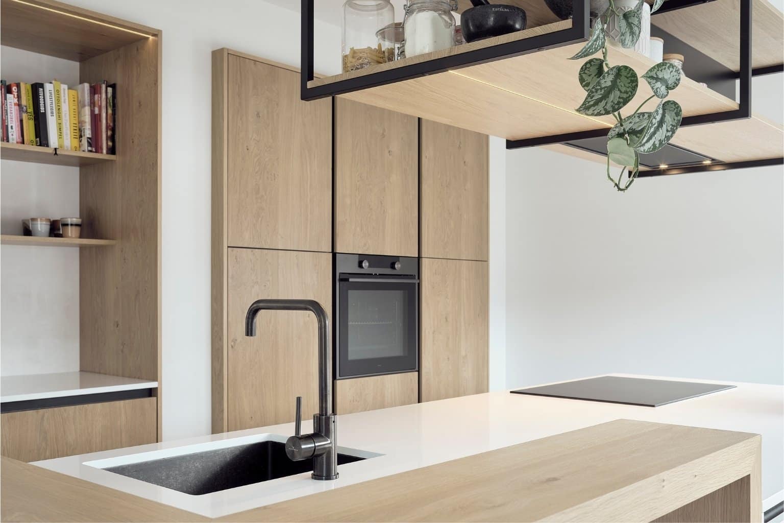 Maatwerk keuken in Oudemirdum met houten kastenwand, zwarte keukenkraan en wit aanrechtblad