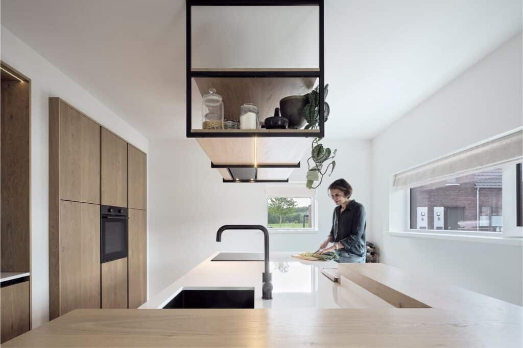 Keukenopstelling met houten fronten, wit kookeiland en zwevende wandplank in Oudemirdum