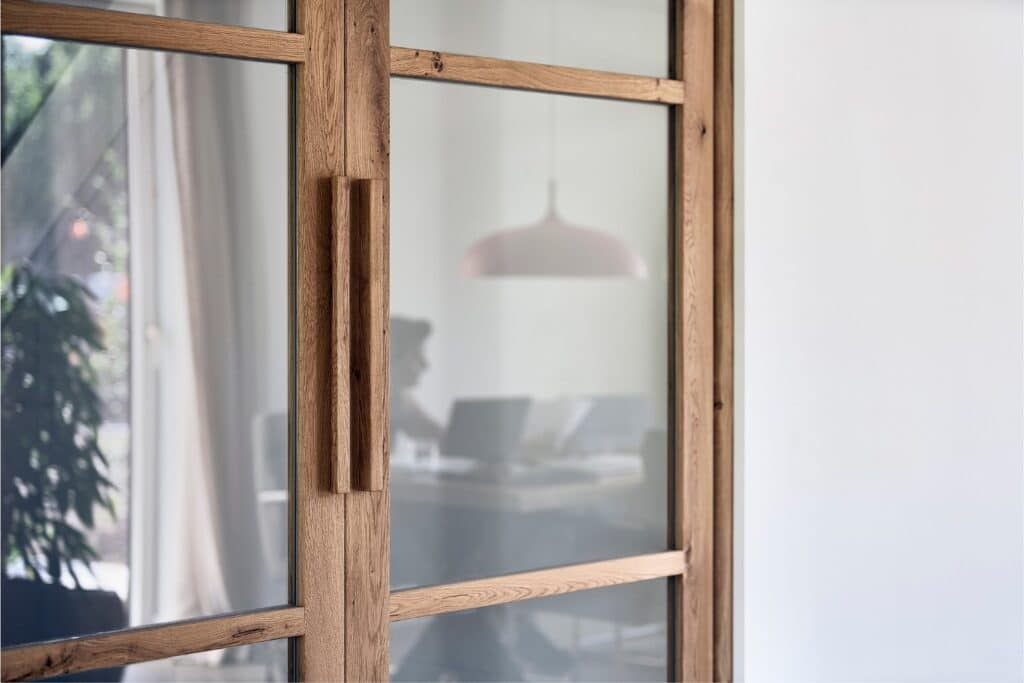 Design binnendeur in hout en glas met zicht op thuiswerkplek