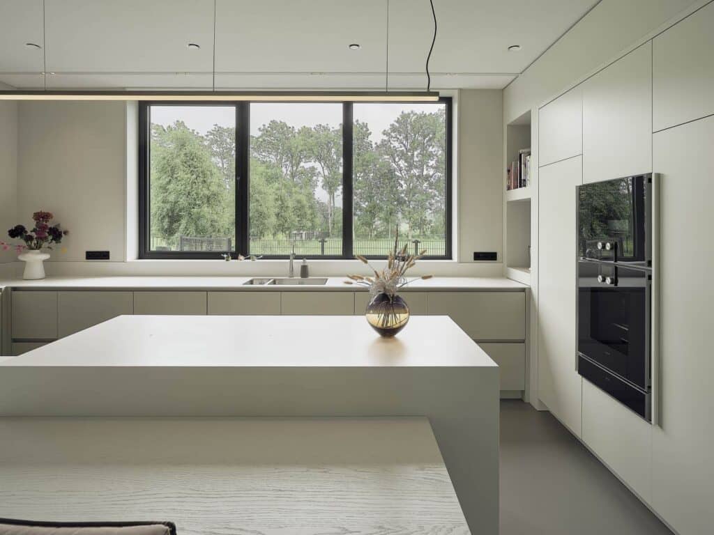Lichte maatwerk keuken met kookeiland en uitzicht op het Friese landschap, onderdeel van interieur in De Friese Meren.