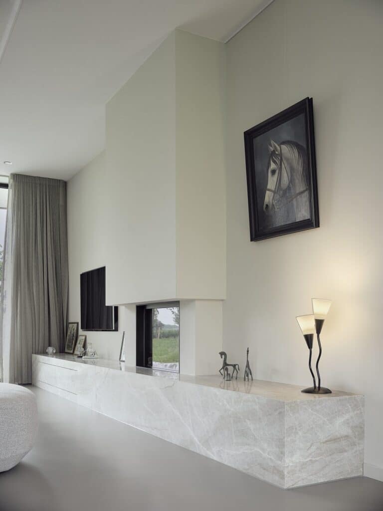 Biobased tv-meubel met geïntegreerde haard en marmerlook afwerking in een lichte woonkamer