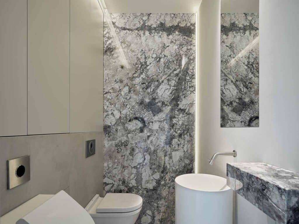 Maatwerk toilet met marmeren achterwand, geïntegreerde waskom en inbouwmeubilair in De Friese Meren.