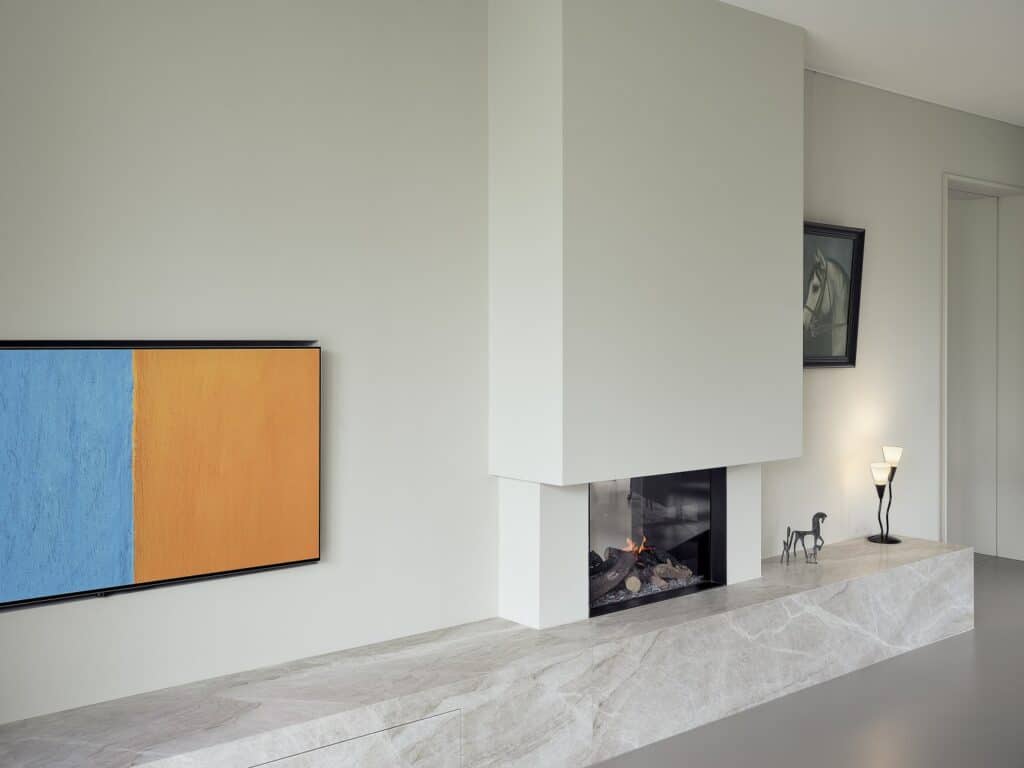 Maatwerk haardmeubel met natuurstenen bank en strakke ombouw, gerealiseerd in Gemeente De Friese Meren.