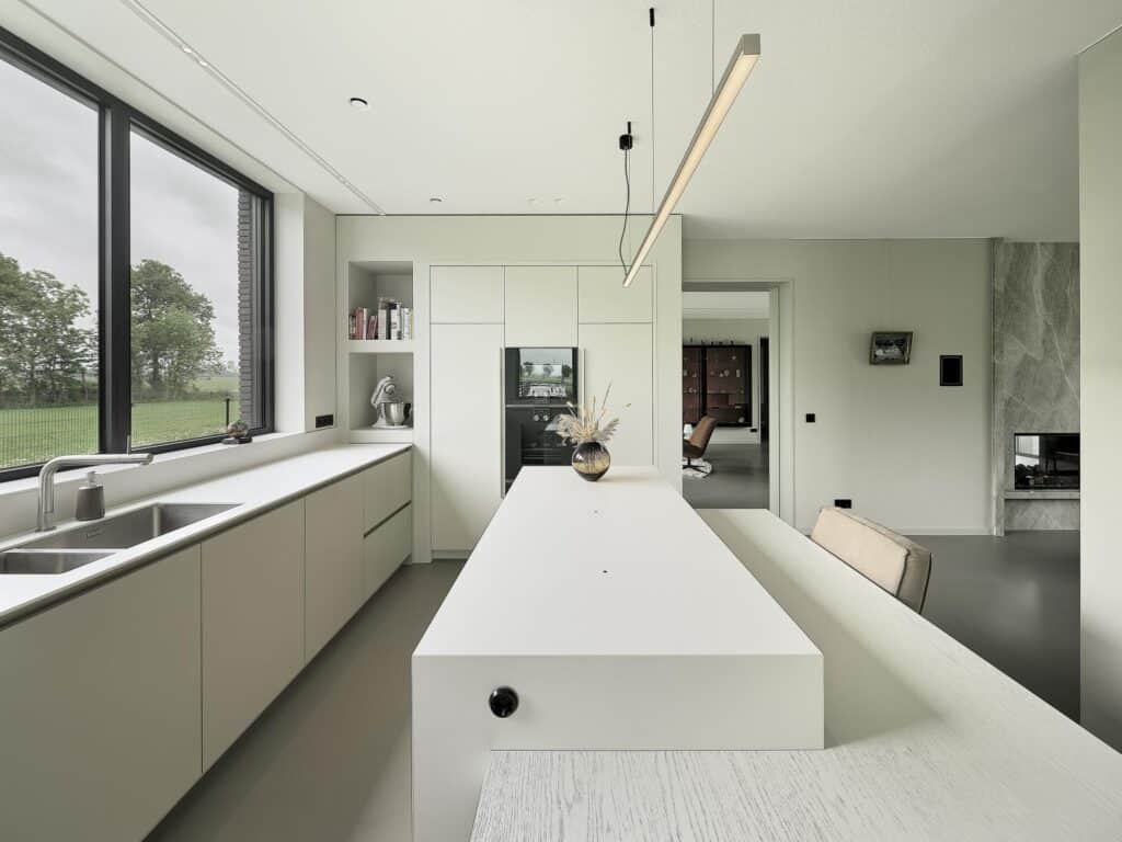 Lichte maatwerk keuken met kookeiland, hoge kasten en uitzicht op het Friese landschap, gerealiseerd in De Friese Meren.