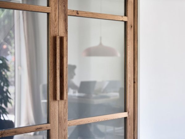 Design binnendeur in hout en glas met zicht op thuiswerkplek