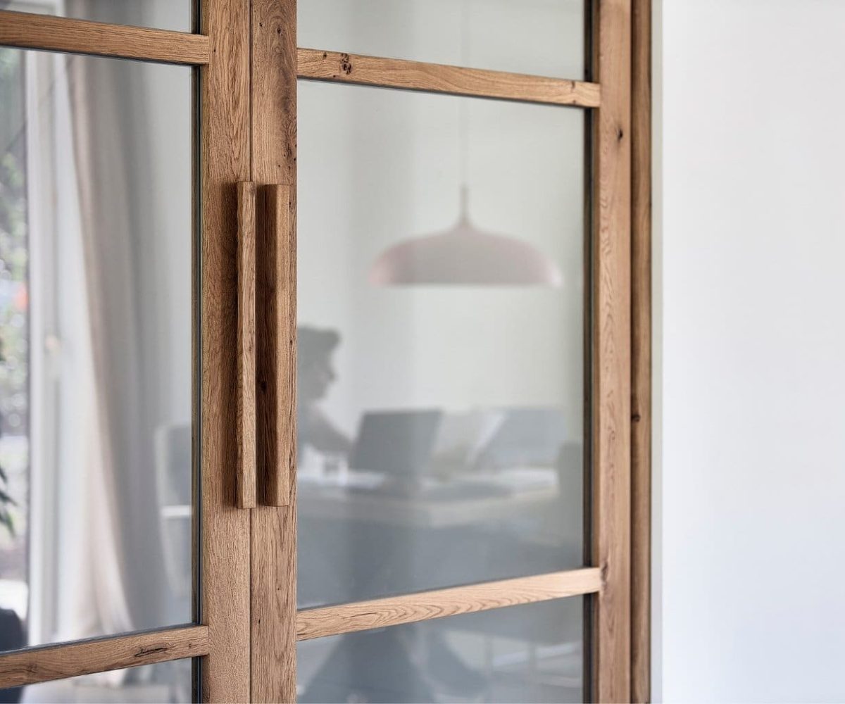 Design binnendeur in hout en glas met zicht op thuiswerkplek