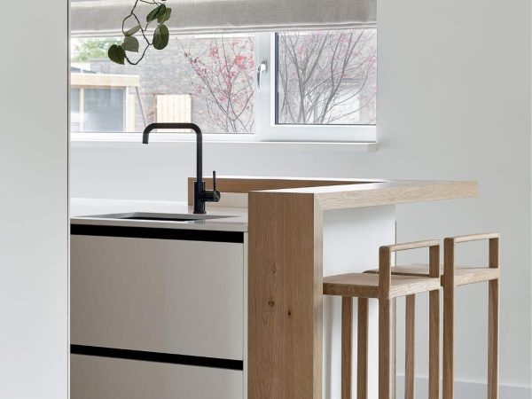 Compact keukenontwerp met ingebouwde bar en zwart keukenkraan