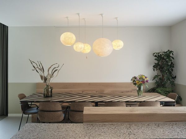 Handgemaakte biobased eettafel en houten zitbank in modern wooninterieur.