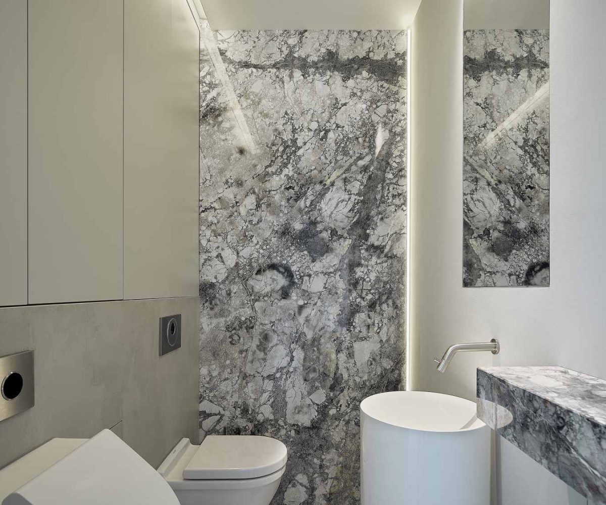 Maatwerk toilet met marmeren achterwand, geïntegreerde waskom en inbouwmeubilair in De Friese Meren.